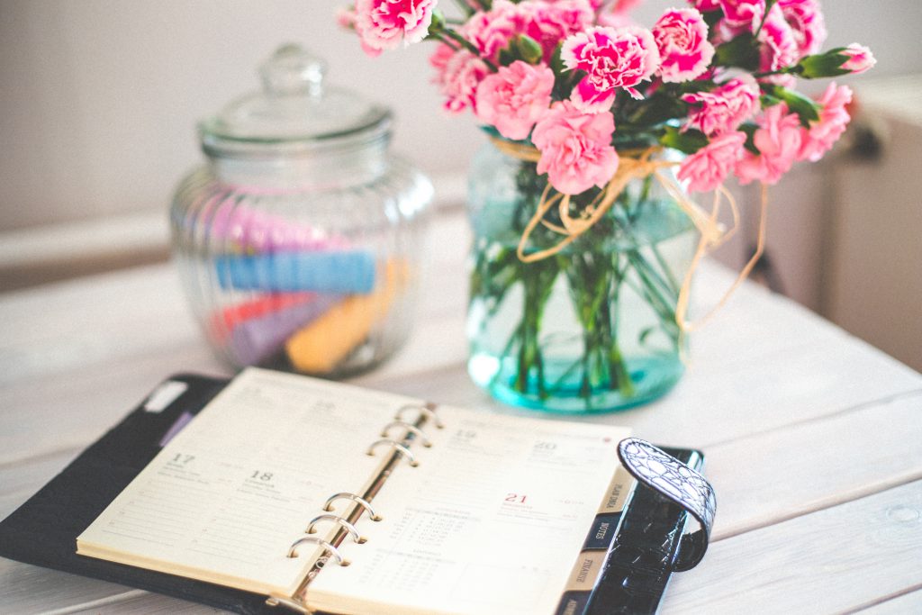 https://www.pexels.com/photo/personal-organizer-and-pink-flowers-on-desk-6374